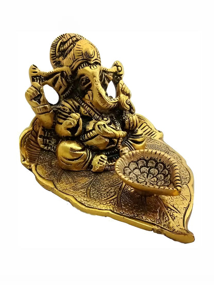 Ganesha Idol Sitting on leaf with diya